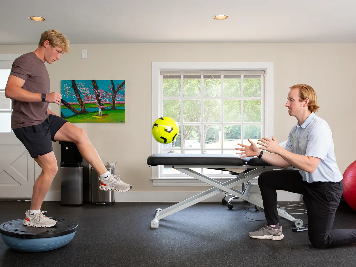 Therapist coaching a patient through single-leg balance training