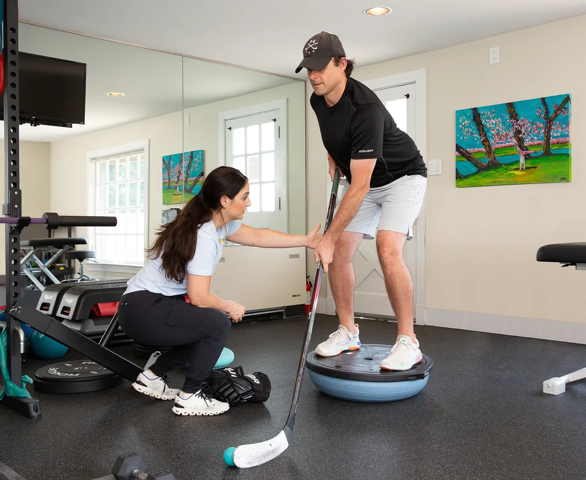 Hockey player training balance with a therapist